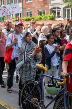 Filistin 'le dayanışmalarını ve Filistin bayraklarıyla el sallamalarını göstermek için gösteri yapan bir grup insan. Kopenhag, Danimarka - 27 Temmuz 2024.