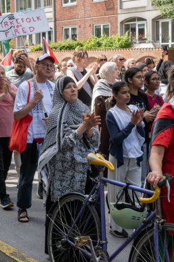 Filistin 'le dayanışmalarını ve Filistin bayraklarıyla el sallamalarını göstermek için gösteri yapan bir grup insan. Kopenhag, Danimarka - 27 Temmuz 2024.