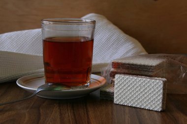 Çay fincanı çay fincanı ve fonda kahverengi tabaklı waffle.