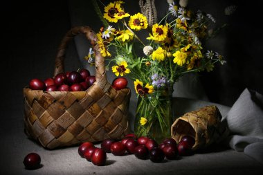 Huş ağacından sepetinde farklı parlak çiçekler ve eriklerle dolu bir yaz.