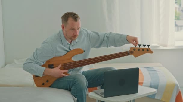 Caucasiano Adulto Homem Afinação Guitarra Sentado Sofá Assistindo Tutorial Line — Vídeo de Stock