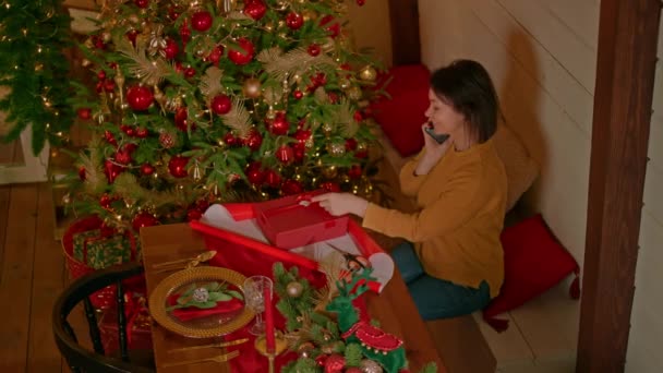 Kobieta Mówi Przez Telefon Komórkowy Zawijania Prezent Świąteczny Patrząc Aparat — Wideo stockowe