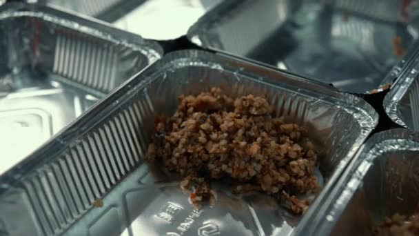 义工把食物放进饭盒免费食品配给工作人员在一个慈善厨房 — 图库视频影像