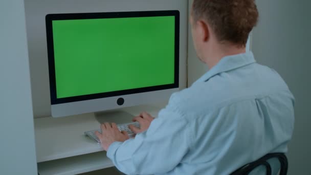 Человек Сидящий Рабочем Месте Печатающий Белой Клавиатуре Зеленым Экраном Фрилансер — стоковое видео