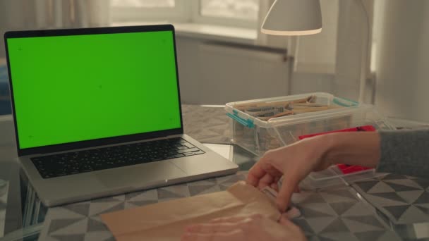 女人把钱放在盒子里存钱 为紧急情况 退休或长期目标积累一个财政缓冲 放在有绿色屏幕的桌上笔记本电脑上 — 图库视频影像
