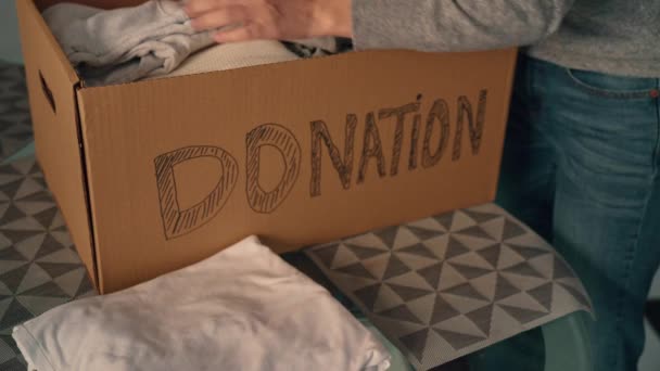 ボランティアは慈善団体に商品を寄付するための服を箱に入れ — ストック動画