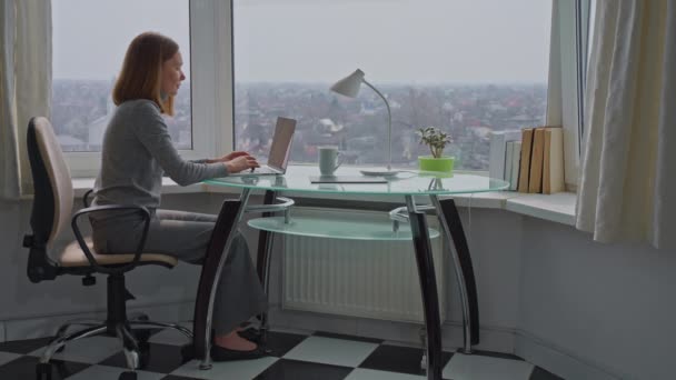 Kobieta Siedzi Przy Biurku Wyłączyć Laptopa Patrząc Przez Okno Cieszyć — Wideo stockowe