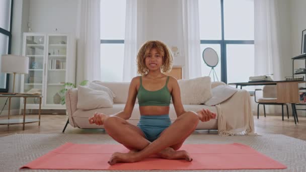 Een Vrouw Zit Een Yogamat Een Woonkamer Houdt Zich Bezig — Stockvideo