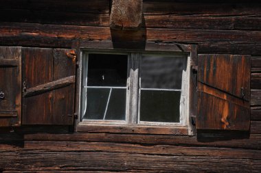 Bahçeli eski bir evin penceresi gibi tahta parçalar.