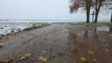 Kışın karla kaplı tarlalar ve çamurlu toprak yol