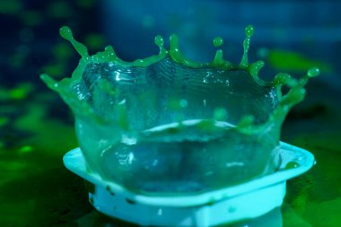 Stüdyoda, arka planda bir damla su çekilmiş.