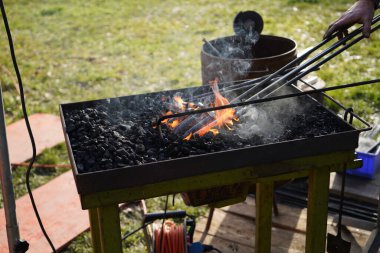 Demirci kızgın kömür ve demirle el işi yapıyor.