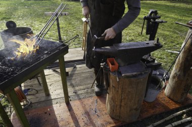 Demirci kızgın kömür ve demirle el işi yapıyor.