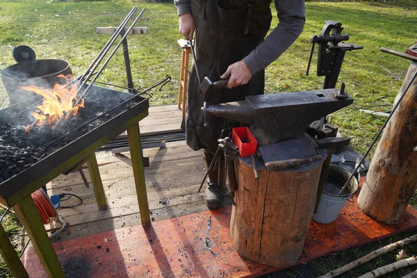 Blacksmith at handwork with glowing coals and iron