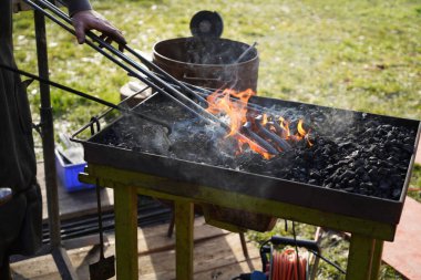 Demirci kızgın kömür ve demirle el işi yapıyor.