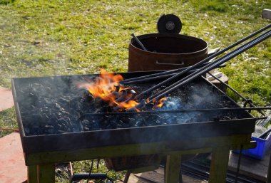 Demirci kızgın kömür ve demirle el işi yapıyor.
