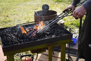 Demirci kızgın kömür ve demirle el işi yapıyor.