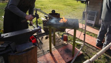 Demirci kızgın demir ve açık kömür ateşiyle iş başında.