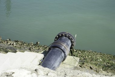Nehir kıyısındaki eski paslı metal boru