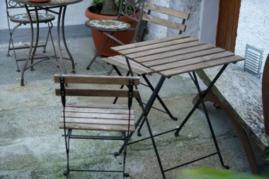 Sandalyeleri ve masaları olan eski ahşap masa.