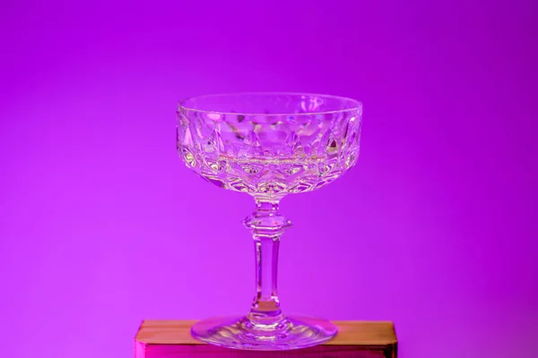 empty glass of wine on a pink background