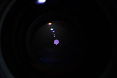 Camera lens with light and lens flare, close-up. Selective focus