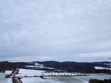 winter with agricultural fields covered with snow in bavaria on a cloudy day