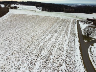 snow-covered agricultural fields in bavaria on a cloudy day