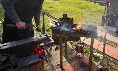 Demirci kızgın demir ve açık kömür ateşiyle iş başında.