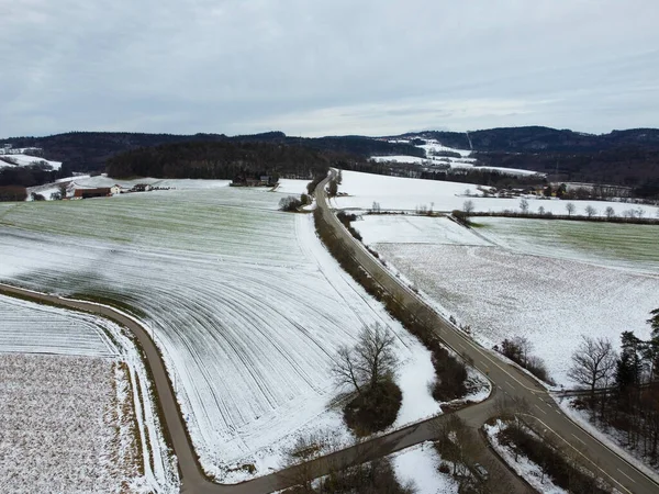 snowy agricultural snowy fields in bavaria on a cloudy day