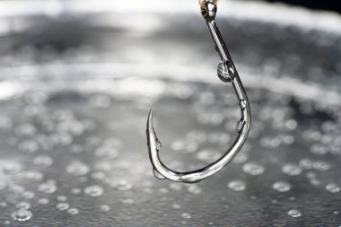 Fishing hook on a dark background. Close-up. Selective focus.
