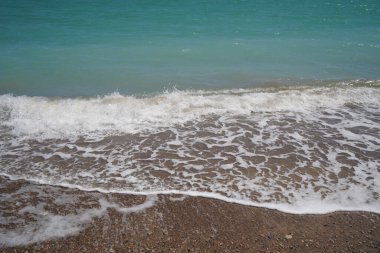 Akdeniz 'de çakıl taşı plajı ve yeşil suyu olan dalgalar