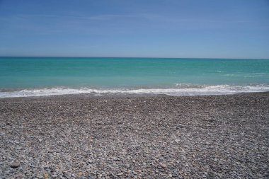 Akdeniz 'de çakıl taşı plajı ve yeşil suyu olan dalgalar