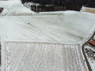 snow-covered agricultural fields in bavaria on a cloudy day