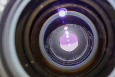 Camera lens with light and lens flare, close-up. Selective focus