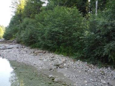 Yukarı Bavyera 'da, güneş doğarken baraj ve büyük taşlarla dolu doğal bir bölgede akarsu, 4k