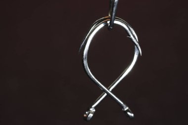 Fishing hook on a dark background. Close-up. Selective focus.