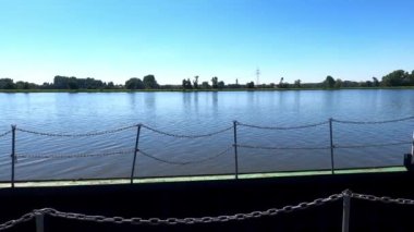 Mavi gökyüzü ve suyla Danube nehrindeki büyük gemiler için paslı iskele
