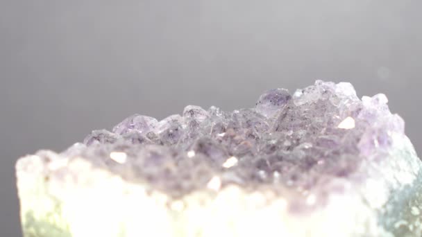 Kwarts Met Glinsterende Kristallen Tegen Een Grijze Achtergrond — Stockvideo