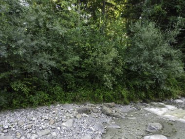 Yukarı Bavyera 'da, güneş doğarken baraj ve büyük taşlarla dolu doğal bir bölgede akarsu, 4k