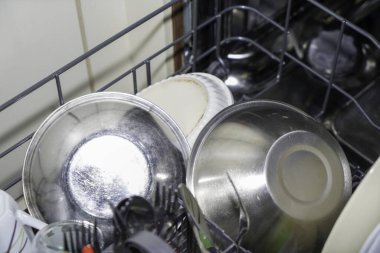 Bulaşık makinesinde temizlenmiş çatal bıçak, bardak ve tabaklar, ev işleri.