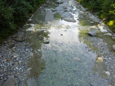 Yukarı Bavyera 'da, güneş doğarken baraj ve büyük taşlarla dolu doğal bir bölgede akarsu, 4k
