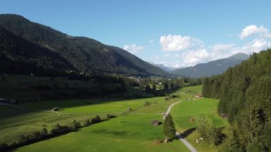 Avusturya 'daki dağlarda yeşil ormanlar ve çayırlar 4k' da alacakaranlıkta.