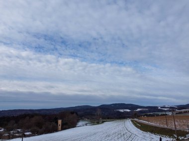 snowy agricultural snowy fields in bavaria on a cloudy day