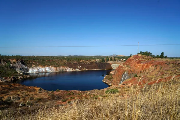 Contaminated pond lake of an old abandoned mining landscape for copper mining with red earth
