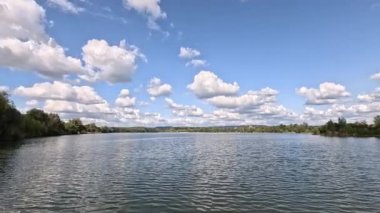 Bavyera sonbaharında ışık dalgaları ve bulutların yansıdığı göl.