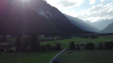 Avusturya 'daki dağlarda yeşil ormanlar ve çayırlar 4k' da alacakaranlıkta.