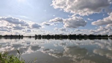 Bavyera sonbaharında ışık dalgaları ve bulutların yansıdığı göl.