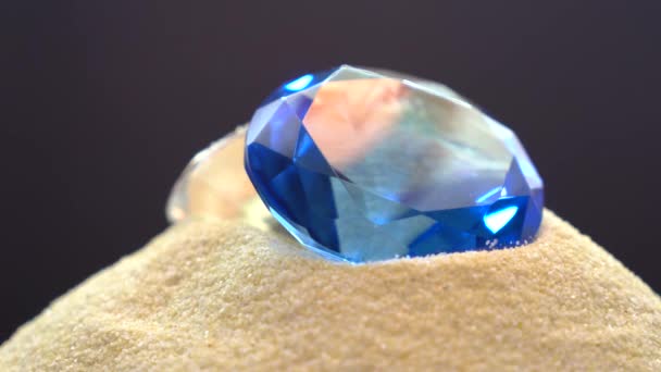 蓝色钻石和黑色背景在沙地上的工作室 — 图库视频影像