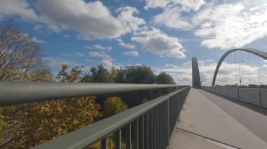Güneşli bir günde Tuna Nehri üzerinde yayalar ve bisiklet yolu bulutlarla kaplı.